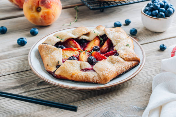 istock Galette, rustic sweet open pie with peach and blueberry on gray marble background. 1432542163