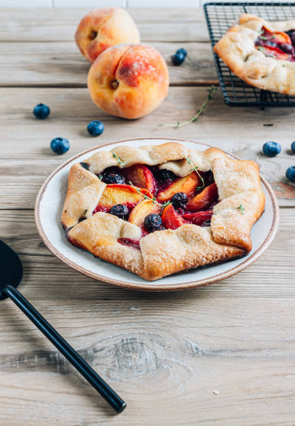istock Galette, rustic sweet open pie with peach and blueberry on gray marble background. 1432542172