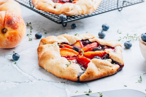 istock Galette, rustic sweet open pie with peach and blueberry on gray marble background. 1432542177