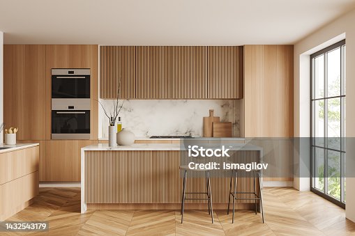 istock Light kitchen interior with bar countertop and seats, shelves and panoramic window 1432543179
