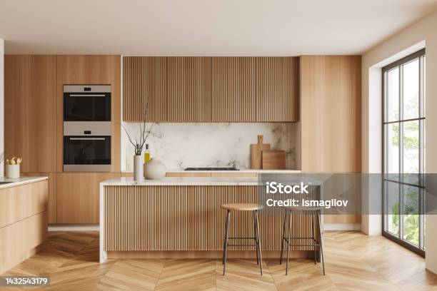 Light Kitchen Interior With Bar Countertop And Seats Shelves And Panoramic Window Stock Photo - Download Image Now