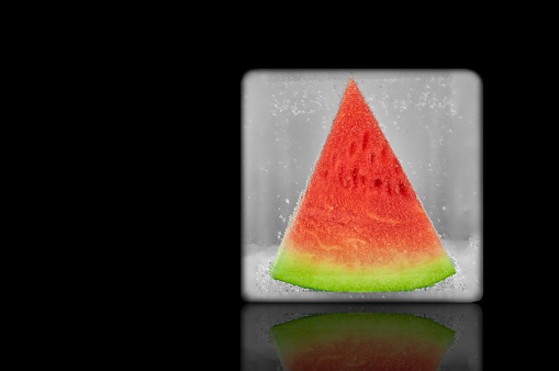 Frozen slice of watermelon. Isolated on a black background. design element
