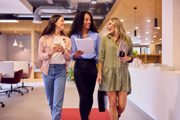 istock Multi-Cultural Female Business Team With Takeaway Drinks Walking Through Open Plan Office 1432544288