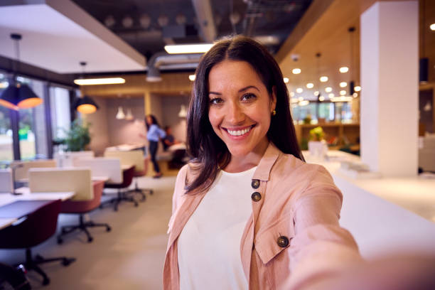 pov selfie portrait de femme d’affaires debout dans un bureau à aire ouverte moderne - selfie photos et images de collection