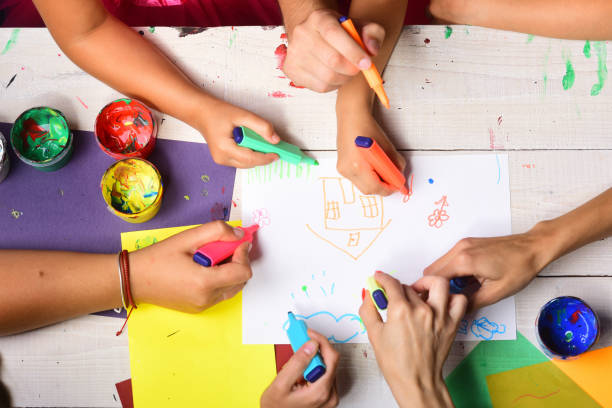 istock Hands hold colorful markers and draw, top view 1432544978