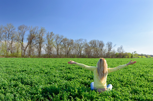Concept of emotions and feelings. Happy woman on the green grass in the meadow