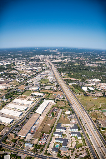 Aerial view of a freeway bisecting a commercial area just outside of downtown Austin Texas from an altitude of about 1000 feet.