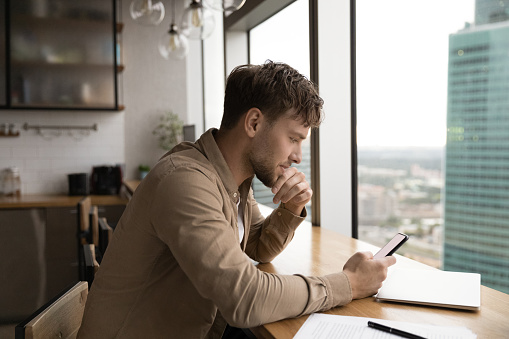 https://media.istockphoto.com/id/1432556776/photo/businessman-sit-by-window-at-kitchen-read-message-on-phone.jpg?b=1&s=170667a&w=0&k=20&c=1DTJUzpgAQ9ZZr46EqrkAjWNWsbV4PcovdszWpQLoU4=