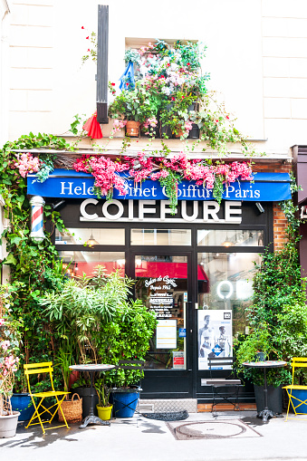 A beautiful entrance to a hair salon, decorated with plants and flowers, in a romantic atmosphere. Paris in France, October 5, 2022.