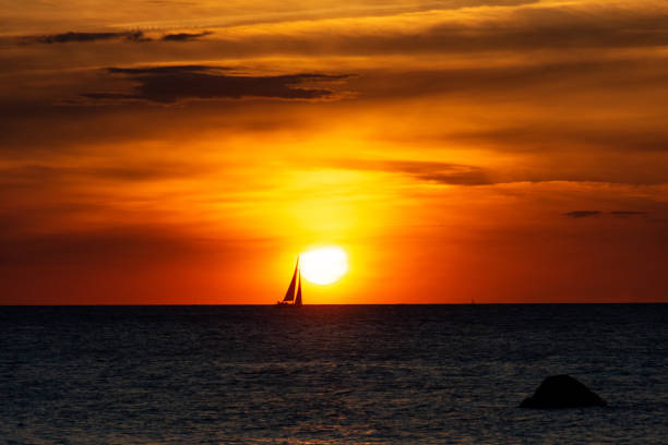 istock Sunset over the sea with a sailing ship on the horizon 1432559378