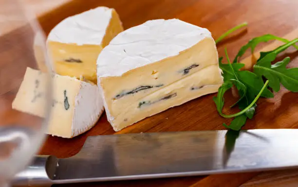 Photo of Appetizing cheese with white and blue mold