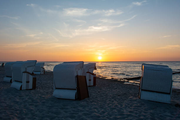 istock Sunset over the sea with beach chairs on the sandy beach 1432562070