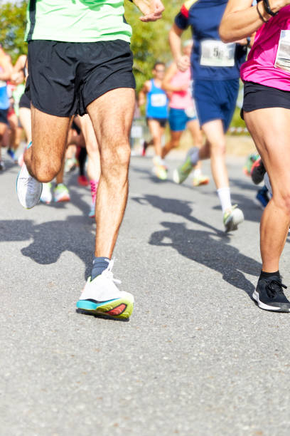 Healthy lifestyle fitness sports persons running. Running race, people feet on city road stock photo