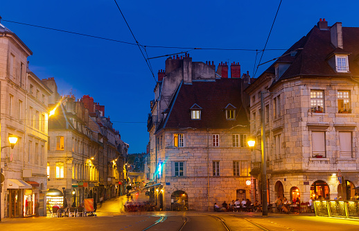 Evening view of illuminated lively historic center of French city of Besancon in summer