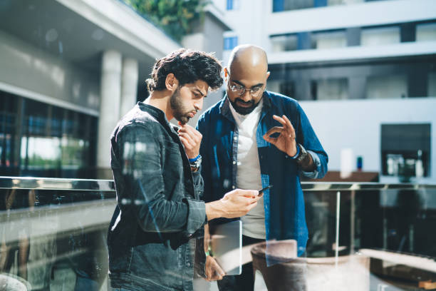 istock Pensive employee showing smartphone to partner 1432563600