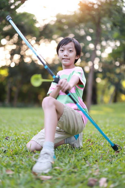 istock Little boy shoots bow in the park 1432564413