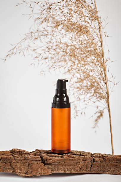 istock Brown glass bottle for cosmetics on a white background. Mockup container for cream on the background of dry cane. 1432564535