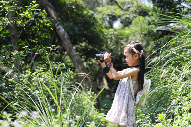 istock a Asian girl take photos with a digital camera. 1432568129