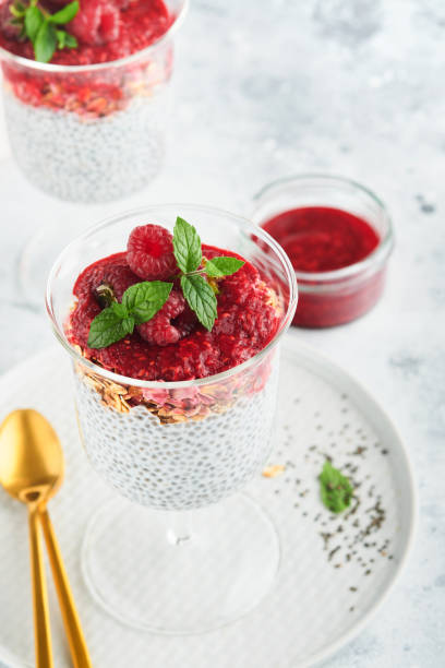 istock Chia pudding. Healthy vanilla chia pudding in glass with fresh raspberries and mint on white background. Vegan healthy breakfast. 1432569145