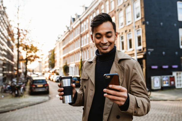 istock Japanese man using smart phone for video call  and drinking coffee on the move 1432570396