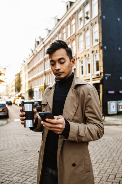 istock Japanese man using smart phone and drinking coffee on the move 1432570432