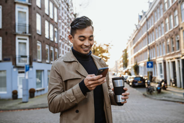 istock Japanese man using smart phone and drinking coffee on the move 1432570541