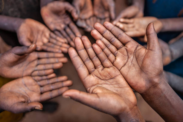 Poor African children keeping their hands up - asking for food. Many African children suffer from poverty - 20% of Africa’s children will die before the age of five.  Every day 30,000 children die from a combination of disease- infested water and malnutrition.