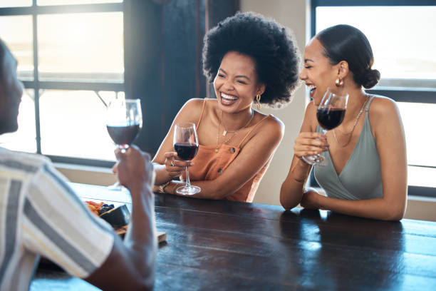 레스토랑에서 함께 와인을 마시고 마시는 행복한 그룹과 우정, 재미 및 축하. 다양한 친구들이 웃고, 술에 취해 평온해지고, 좋은 소식과 자유를 축하합니다. - south africa wine africa indoors 뉴스 사진 이미지