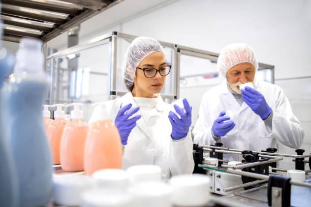 Team of technologists inside production factory doing quality control of pharmaceutical products for cosmetics industry.