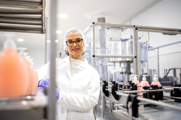 Female technologist technician standing inside manufacturing factory producing cleaning chemicals for domestic and industrial usage.