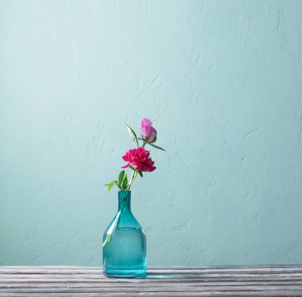 istock pink peonies in glass vase on blue background 1432579888