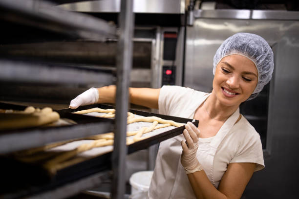 istock Working in bakery food production preparing raw bread and pastry for baking. 1432580308