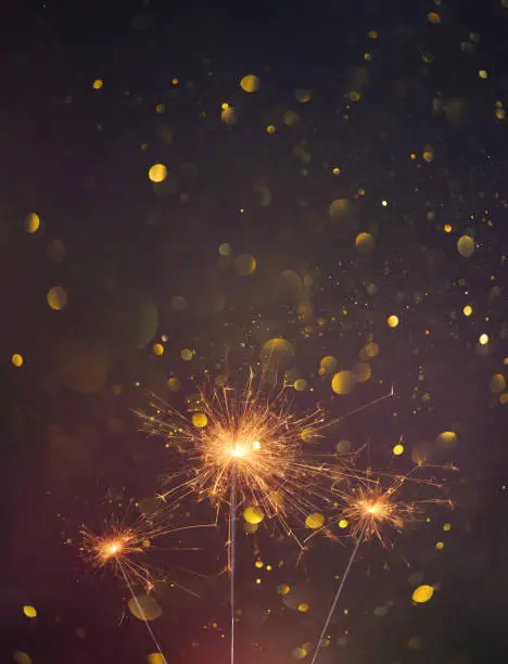 Photo of Happy New Year, Sparklers burning bright with shiny sparks and bokeh festive Silvester party