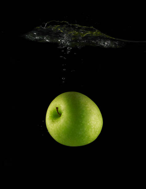 istock Green ripe apple falls in water 1432582845