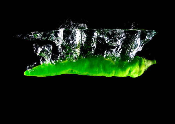 Hot peppers green falling in water. design element