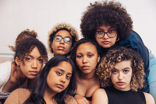 Multi ethnic group of women posing for a studio shot, empowerment women concept they are young american students.