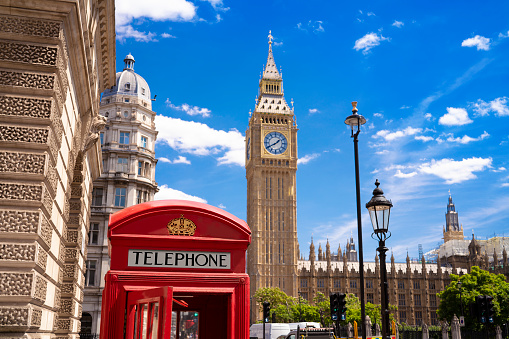 London Big Ben tower and red telephone box with a red Bus in Westminster London in a summer blue sky sunny day in England UK Great Britain United Kingdom