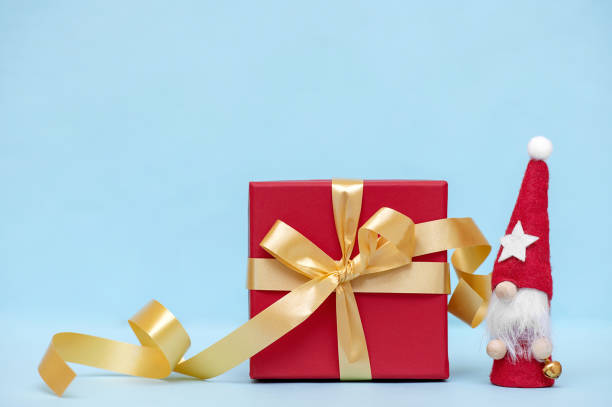 istock Festive Christmas background with gift box and little gnome. 1432584998