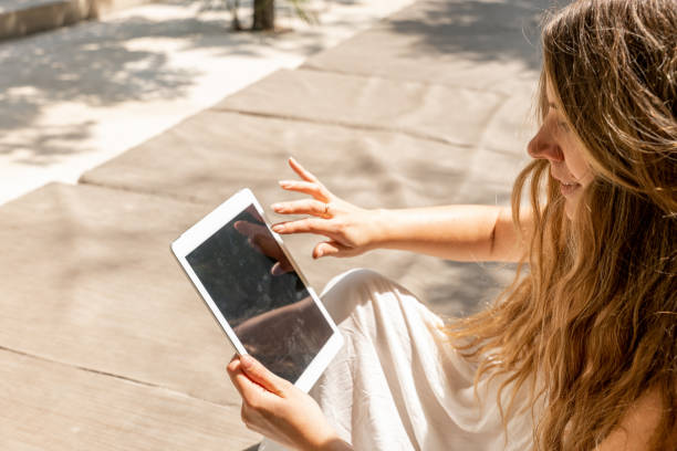 istock Caucasian young woman using a digital tablet outdoors 1432585880