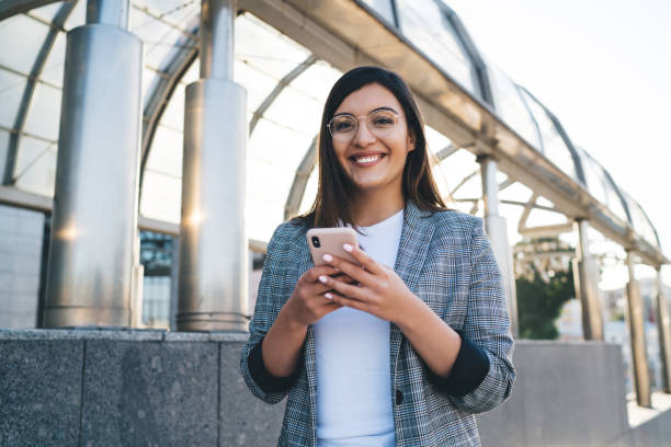 istock Delighted woman with smartphone near roofed passage 1432589466