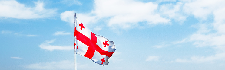 flag of Sakartvelo or Georgia banner. flag of Sakartvelo or Georgia waving in the wind against the blue sky