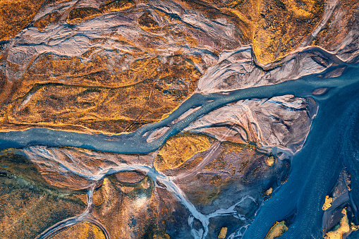 Top view of abstract glacier rivers pattern flowing through volcanic lava field in Icelandic highlands on summer at Iceland