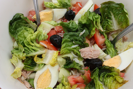 Salad made with lettuce rice tuna hard-boiled egg olives tomato cucumber  Meal buffet