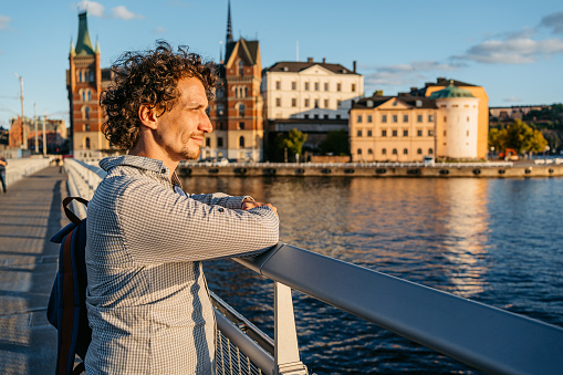 Handsome young man enjoying the view on the bridge in Stockholm, Sweden.