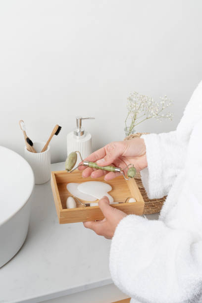 istock female hand holding jade massage face roller in bathroom 1432596181