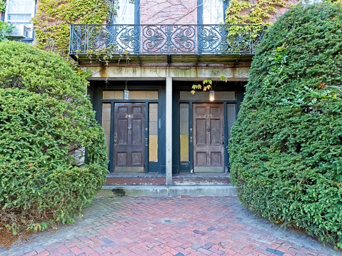 Front doors of duplex home along Main street in Bradford - Haverhill Massachusetts, September 2022. Twin doors of entry into duplex residential home with brick pavers.