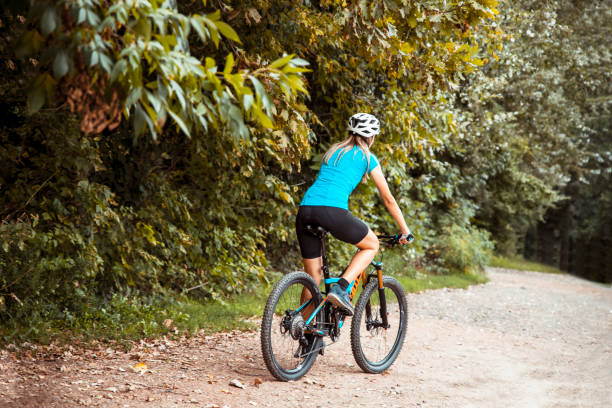 istock Woman mountain biker riding through the forest 1432605494