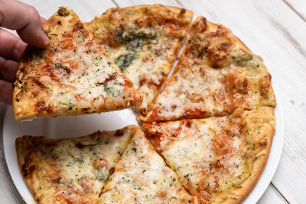 istock Sliced pizza with blue cheese on a white plate. Pieces of freshly cooked pizza. 1432606696
