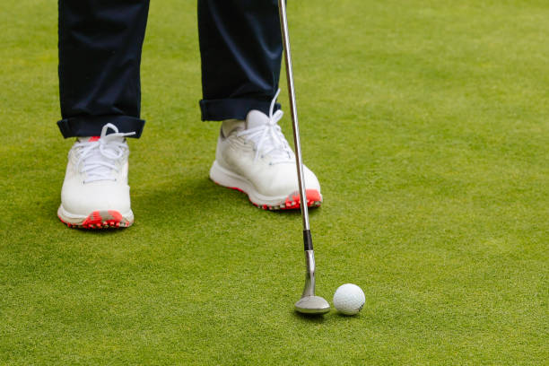 istock foot of golfer with putting golf ball, copy space 1432610684