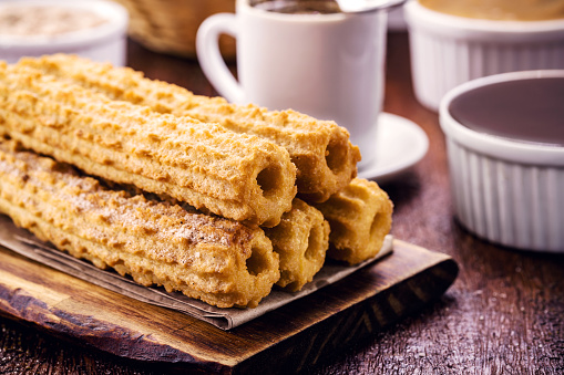 Churros, a typical fried sweet from Brazil, Mexico and Spain, made from wheat flour and water, in a cylindrical shape. Sprinkled with a layer of sugar or cinnamon